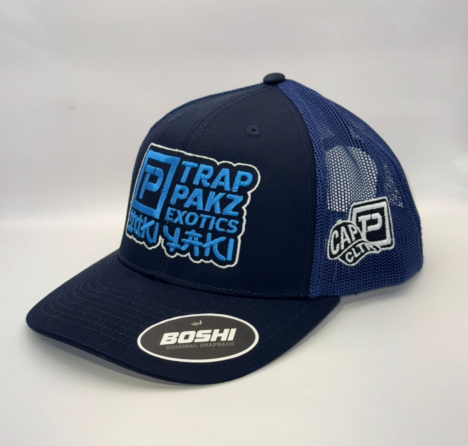 Navy blue cap with multiple brand logos on a white background